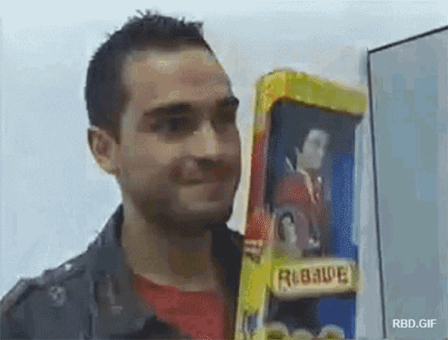 a man is holding a doll in a box that says robade