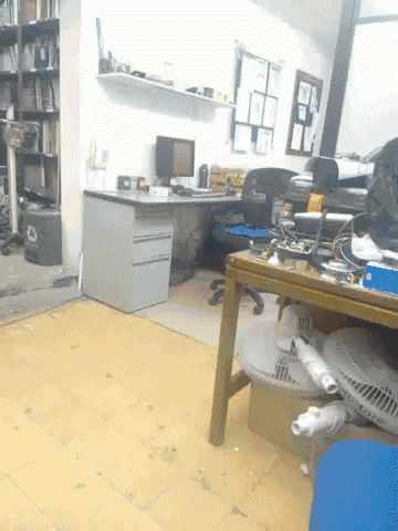 a messy office with a desk and chairs and a recycle bin