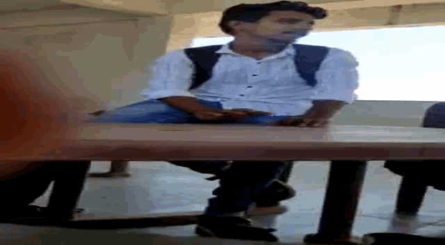 a man sitting at a table with his legs crossed