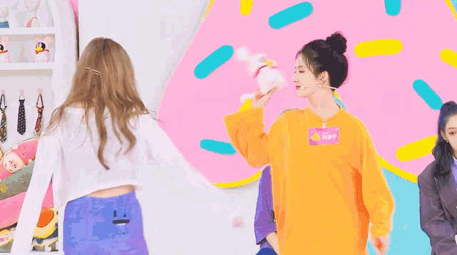 a woman wearing an orange sweater has a name tag that says ' snoop ' on it