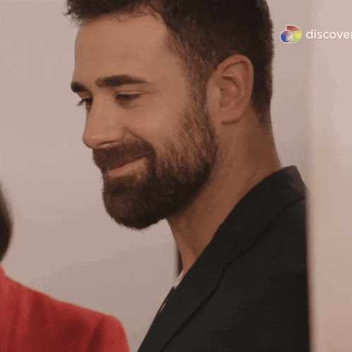 a close up of a man 's face with the discovery logo in the background
