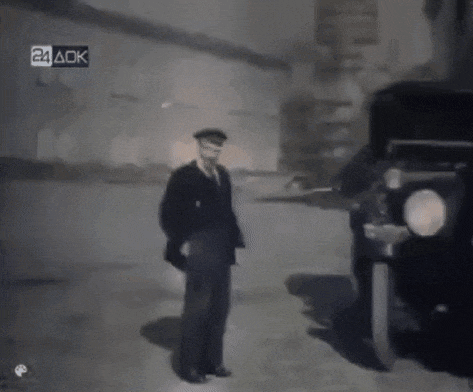 a black and white photo of a man standing next to a car with the letters 24 aok visible