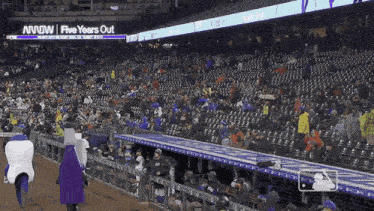 a crowded stadium with a sign that says five years out