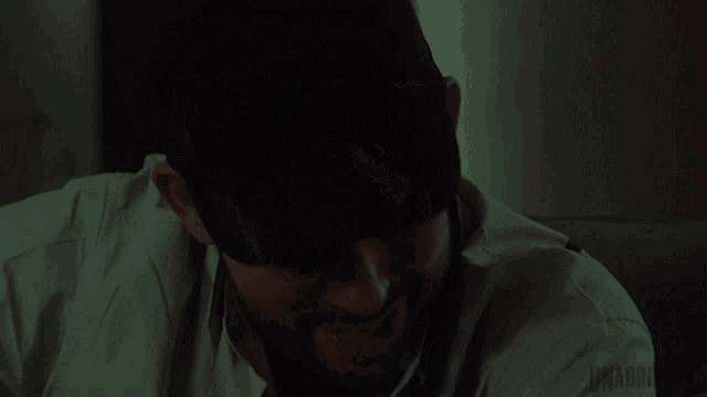 a man is smiling in a dark room with the word unadroid written on the bottom