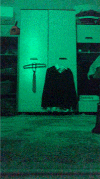 a green room with a sweater and tie hanging on a rack
