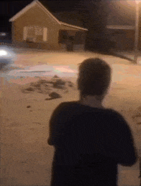 a blurry picture of a man standing in front of a house at night