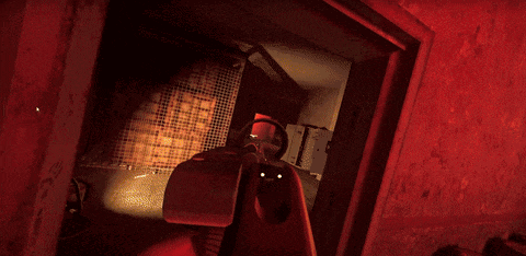 a person holding a gun in a dark room with red lighting