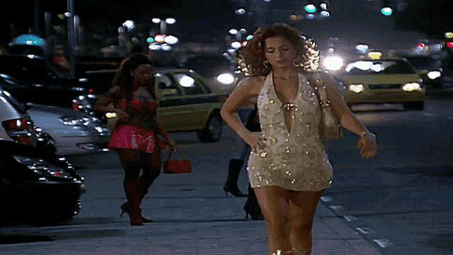 a woman in a white dress walks down a street