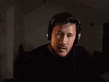 a man with a beard wearing headphones making a funny face