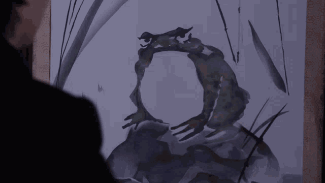 a man looks at a painting of a frog with a circle in the middle