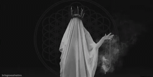 a black and white photo of a ghost wearing a crown and a white cloth .