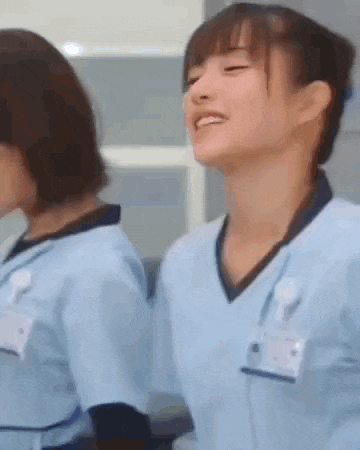 two nurses are standing next to each other in a hospital room .