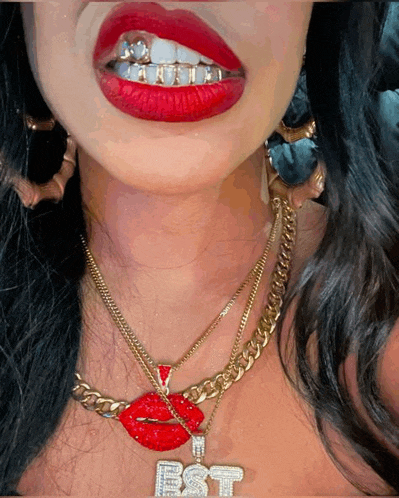 a close up of a woman 's mouth with a necklace that says est