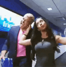 a man in a suit and a woman in a black dress are standing next to each other in a room .