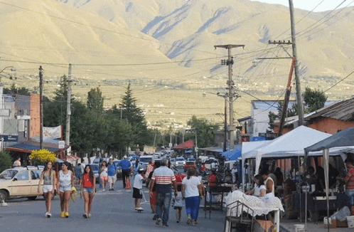 a group of people walking down a street in front of a sign that says ' banco ' on it