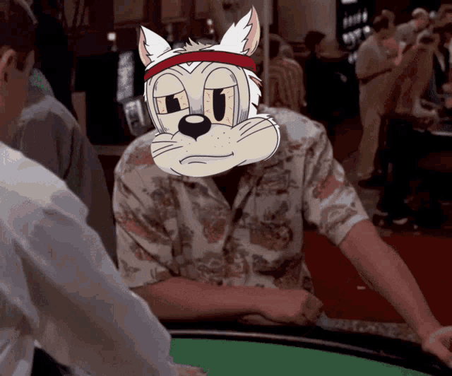 a man is playing poker with a cartoon cat on his head
