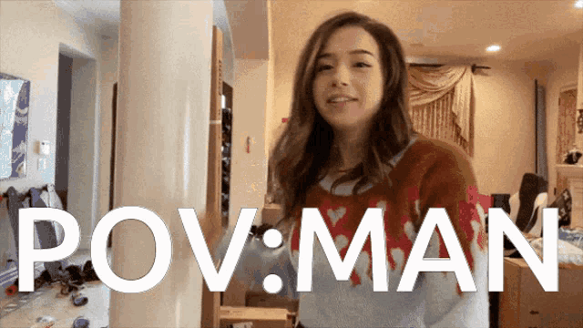 a woman in a sweater stands in front of a sign that reads pov man