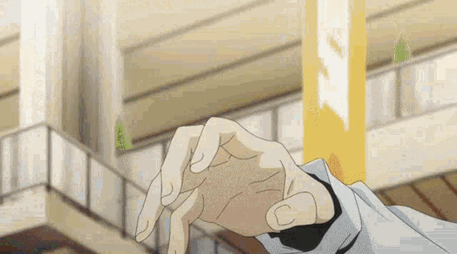 a close up of a person 's hand reaching out towards a pole .