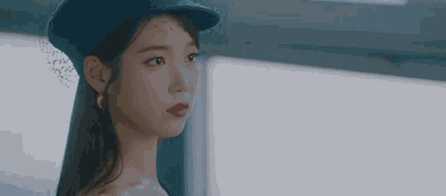 the woman is wearing a blue hat and red lipstick .