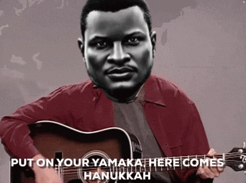 a man playing a guitar with the words put on your yamkah here comes hanukkah