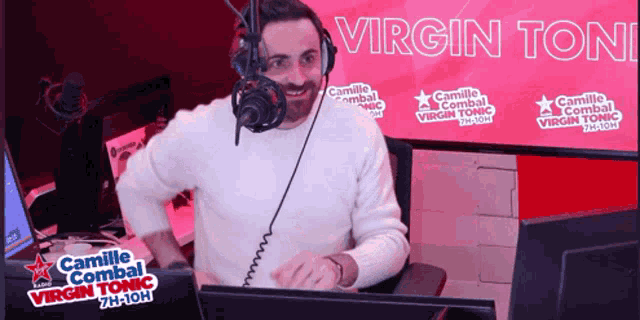 a man wearing headphones stands in front of a microphone with the words virgin tonic on the bottom
