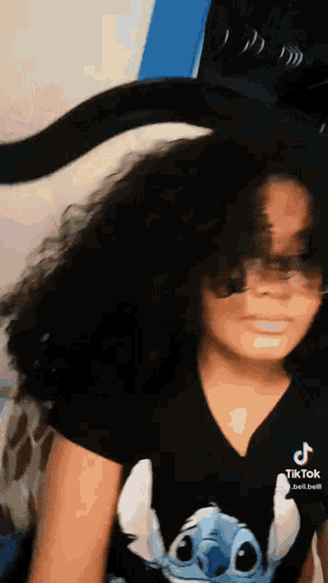 a young girl wearing a black shirt with a stitch on it