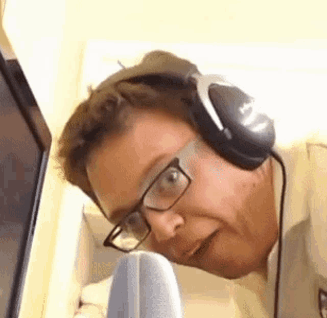 a man wearing headphones and glasses is making a funny face .