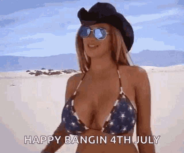 a woman in a bikini is wearing a cowboy hat and sunglasses on the beach .