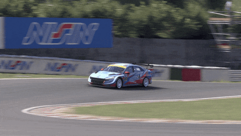 a race car is on a track with a sign that says nigin on it