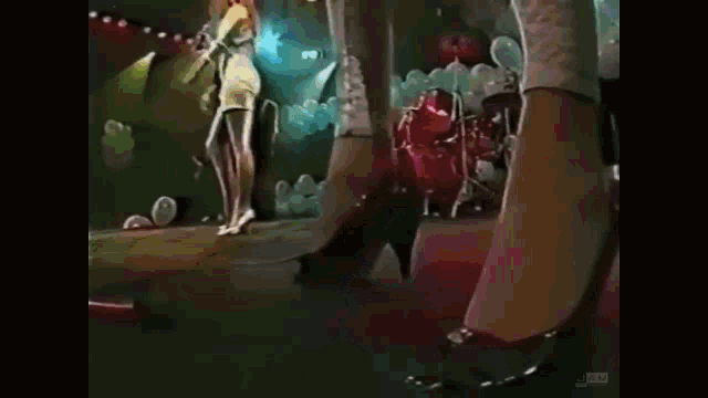a group of women are dancing on a stage with balloons in the background ..