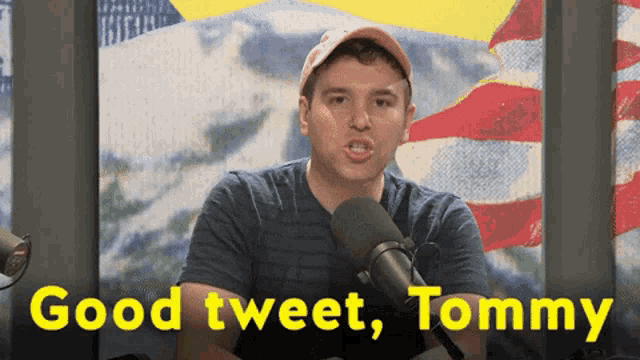 a man in front of a microphone with the words " good tweet tommy " below him