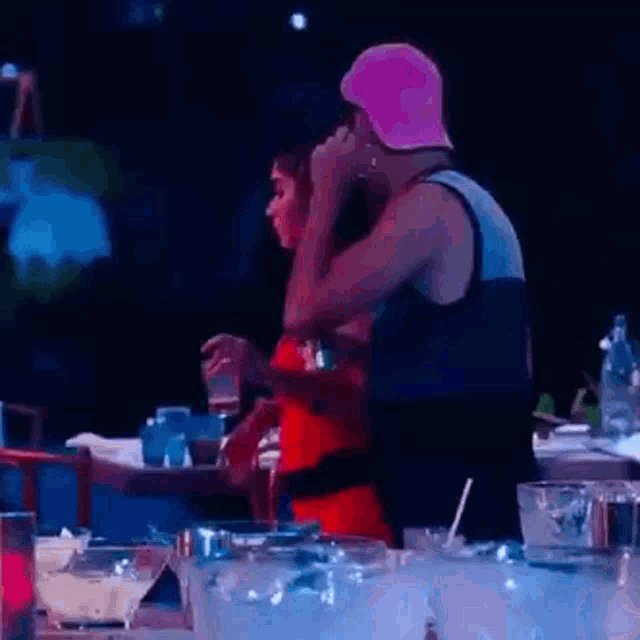 a man and a woman are standing next to each other at a bar .