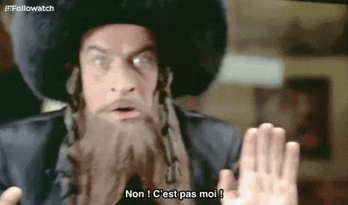 a man with a beard and a hat is making a stop gesture .
