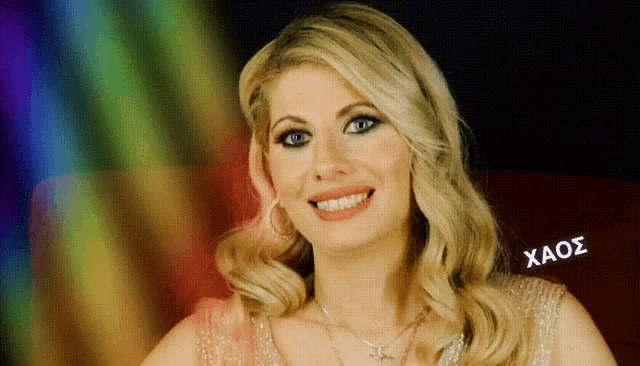 a woman in a pink dress is smiling and the word xaos is on the bottom