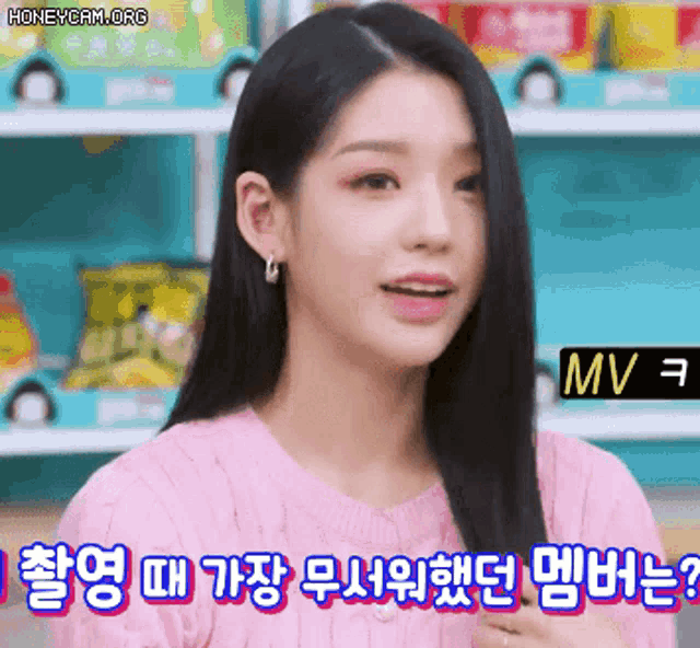 a woman in a pink sweater is talking in a foreign language