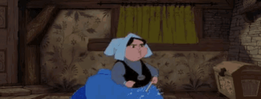 a woman in a blue dress is sitting in a room holding a wand .
