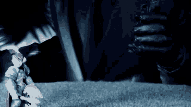 a person in black gloves is holding a toy figure in their hand