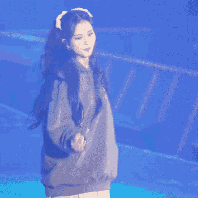 a woman with long hair is holding a microphone and dancing on stage