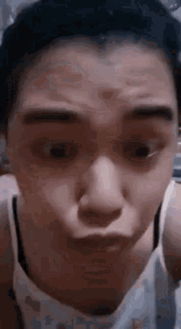 a woman is making a funny face with her mouth open and looking at the camera .