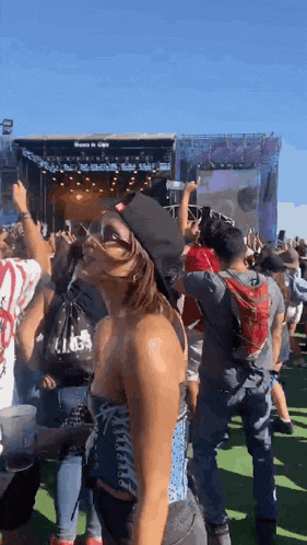 a woman is dancing in front of a crowd at a festival