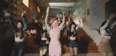 a group of girls are dancing in front of a sign that says rar