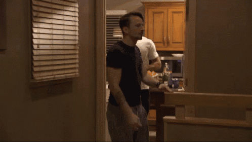 a man in a black shirt is standing in a hallway