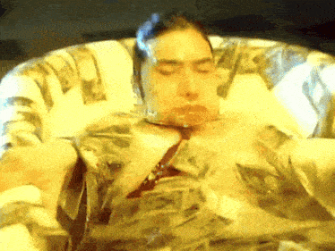 a man in a bathtub is covered in money
