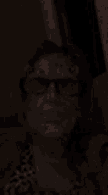 a blurry photo of a woman wearing glasses and makeup