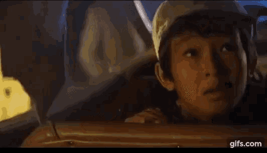 a young boy in a hat is sitting in a car and saying `` wow ! holy smoke '' .