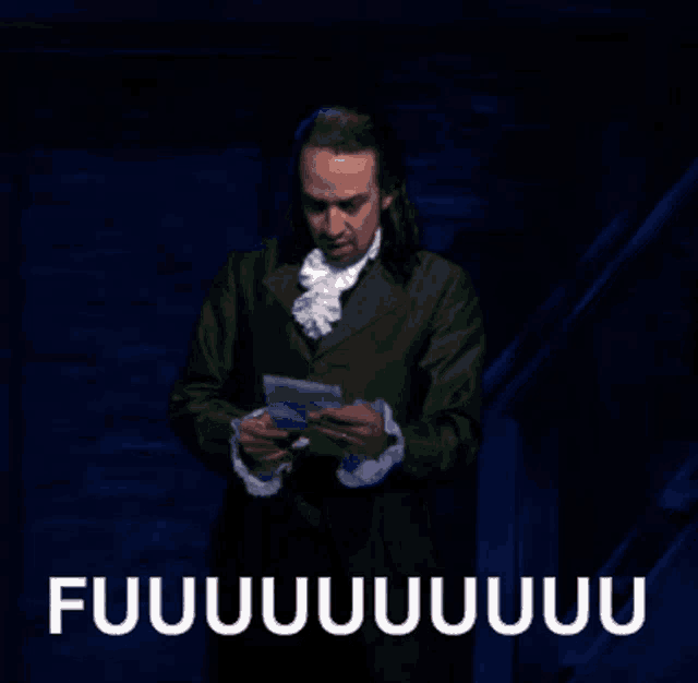 a man in a green suit is holding a piece of paper in his hands and says fuuuuuuuu