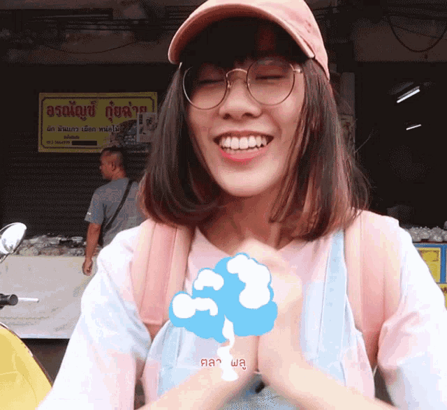 a girl wearing glasses and a pink hat stands in front of a yellow sign that says ' a ' on it