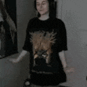 a person wearing a black shirt with a lion on it is standing in a room .