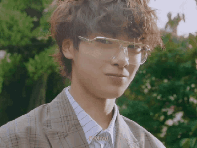 a young man wearing glasses says money