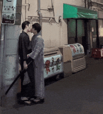 a couple kissing in front of a sign that says 481-3 on it